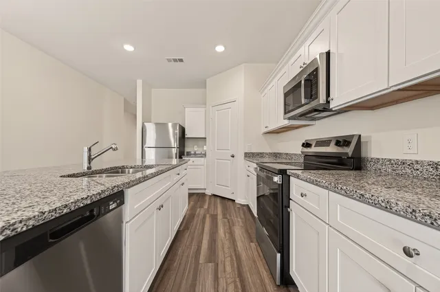 a kitchen with granite countertop a sink and cabinets