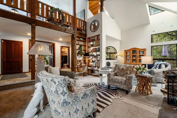 a living room with furniture a large window and a potted plant