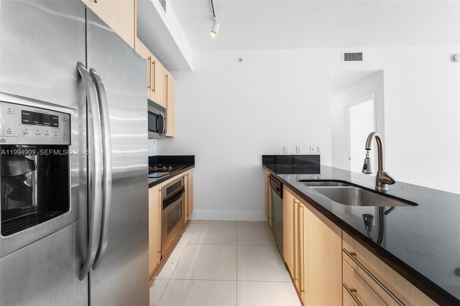 79 Southwest 12th Street, Unit 2108S Miami, FL 33130 - Photo 3 of 16 a kitchen with stainless steel appliances granite countertop a sink and a stove