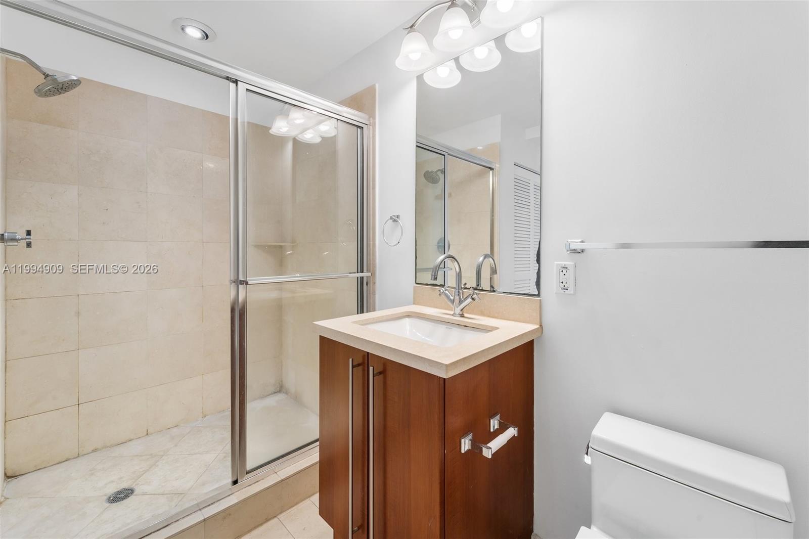 79 Southwest 12th Street, Unit 2108S Miami, FL 33130 - Photo 10 of 16 a bathroom with a sink a toilet a mirror and shower