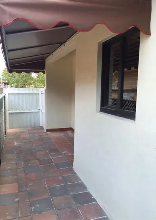 a balcony with potted plants and a wooden bench