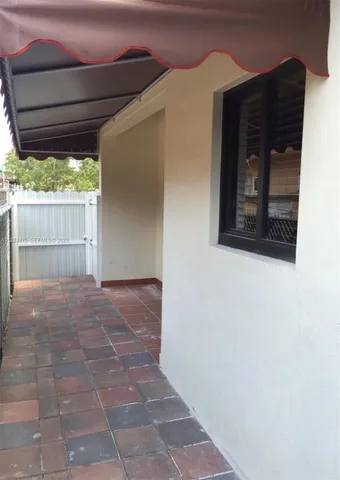 a view of a hallway with wooden floor and a glass door