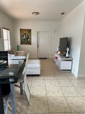 a living room with furniture a flat screen tv and a table
