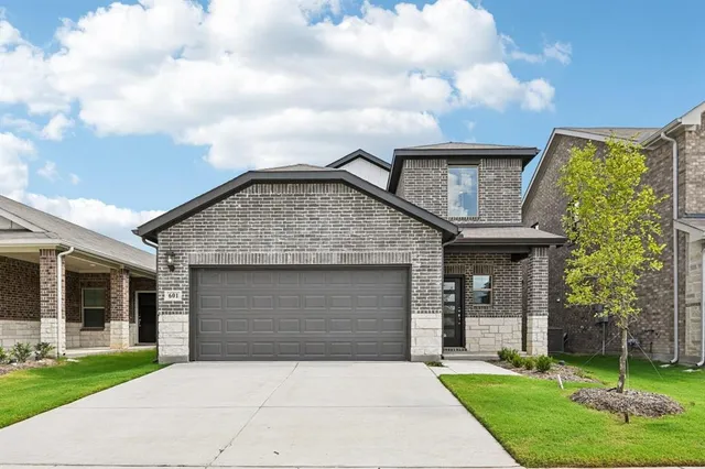 a front view of a house with a garden and yard