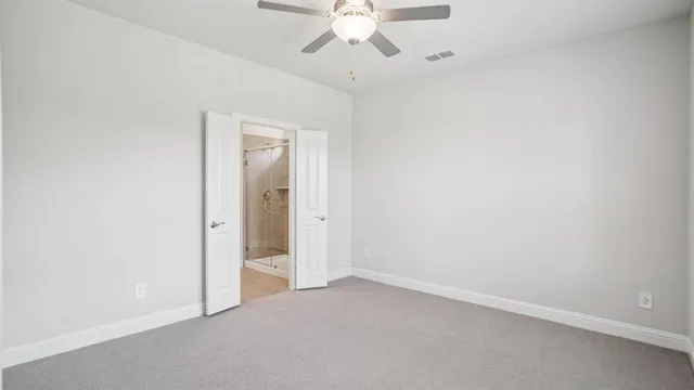 an empty room with a ceiling fan and a window