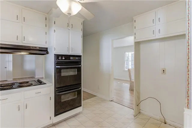 a kitchen with white cabinets and appliances