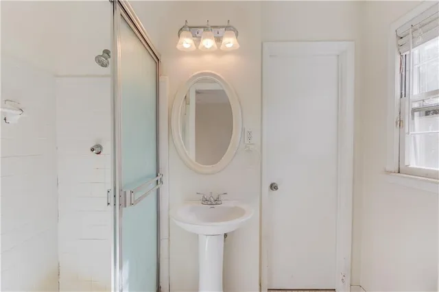 a bathroom with a sink a mirror and a shower