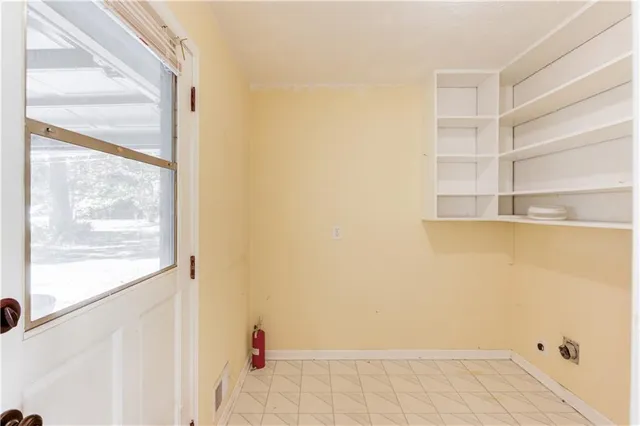 a view of a small space with wooden floor and a window