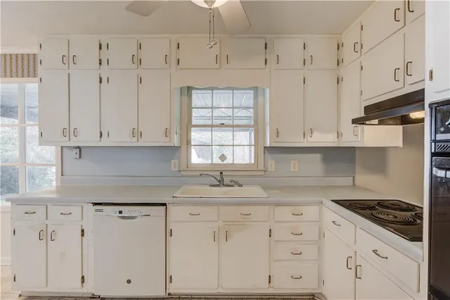 a kitchen with white cabinets and appliances