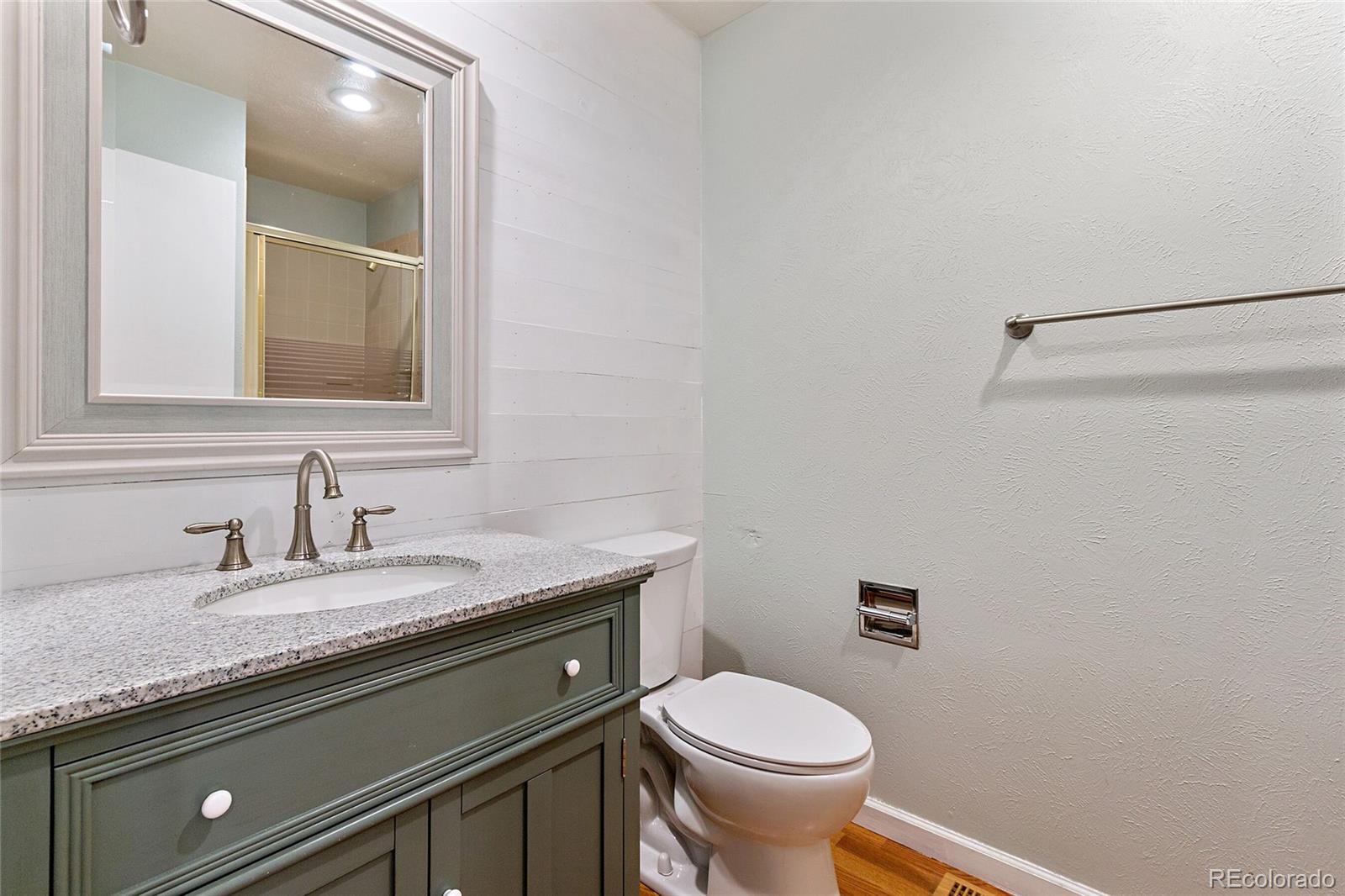 7503 Rattlesnake Drive Lone Tree, CO 80124 - Photo 14 of 29 a bathroom with a granite countertop sink a toilet and a mirror