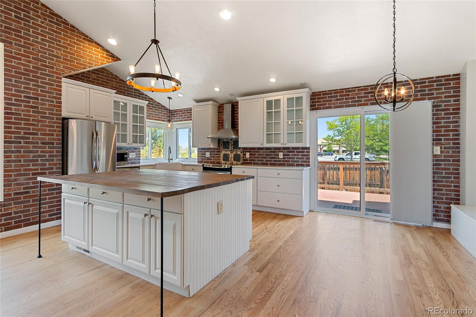 7503 Rattlesnake Drive Lone Tree, CO 80124 - Photo 5 of 29 a kitchen with stainless steel appliances granite countertop wooden floors stove and sink