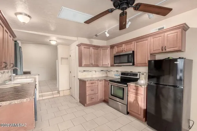a living room with stainless steel appliances kitchen island granite countertop furniture a sink and a large mirror