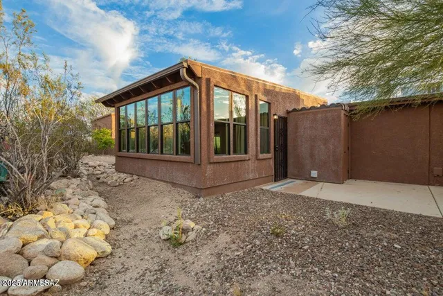 a view of patio with a table and chairs and couches with wooden floor and fence