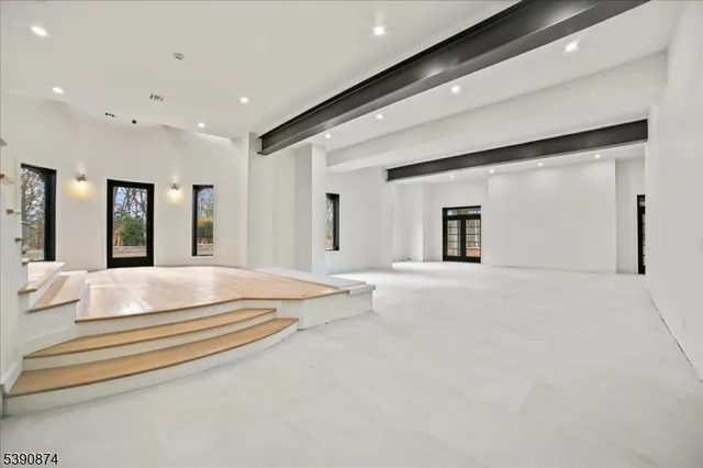 a spacious bedroom with a large bed and chandelier