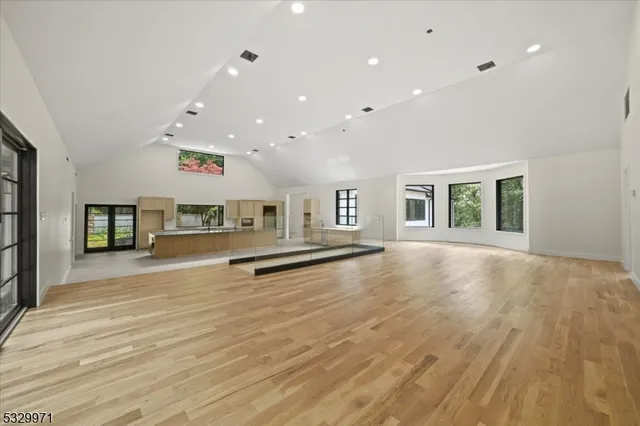 a large white kitchen with stainless steel appliances granite countertop a large counter top and a stove