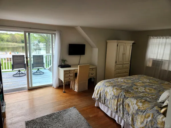 a bedroom with a bed and a flat tv screen on the dresser