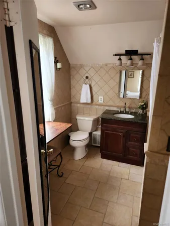 a bathroom with a toilet sink and mirror