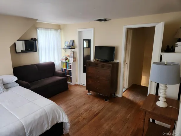 a bedroom with furniture and a flat screen tv