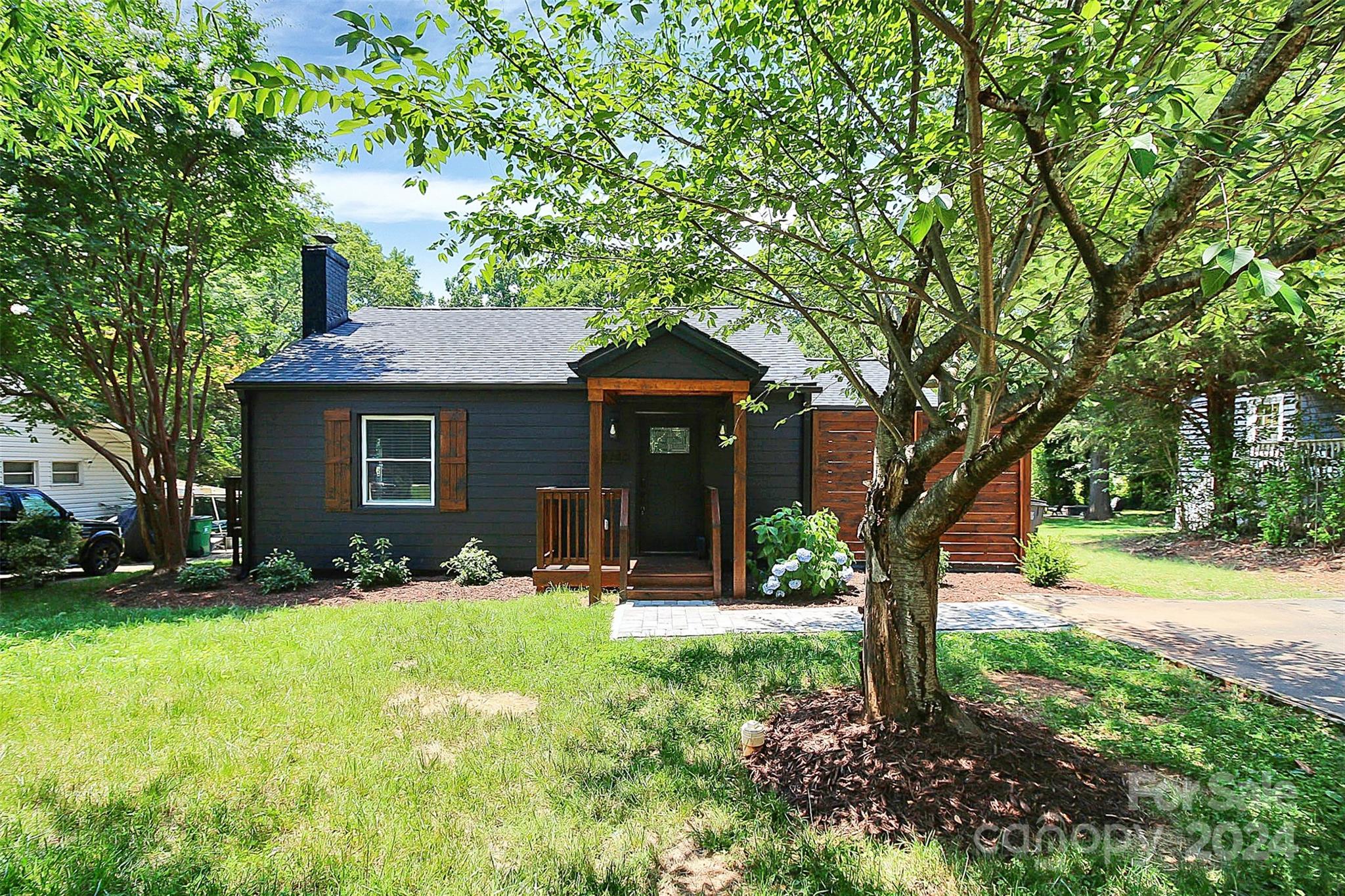 a front view of a house with a yard and trees
