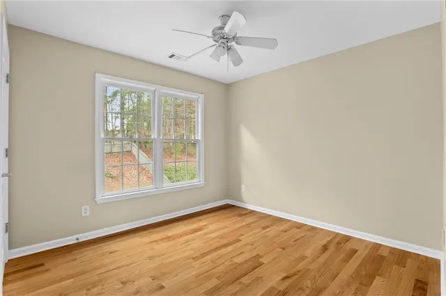 an empty room with a window and a ceiling fan