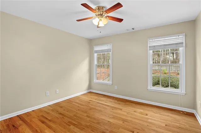 a view of an empty room with window and wooden floor