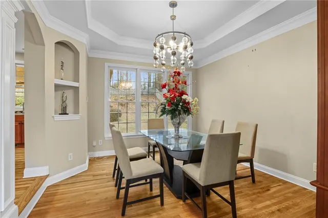 a dining room with furniture a chandelier and wooden floor