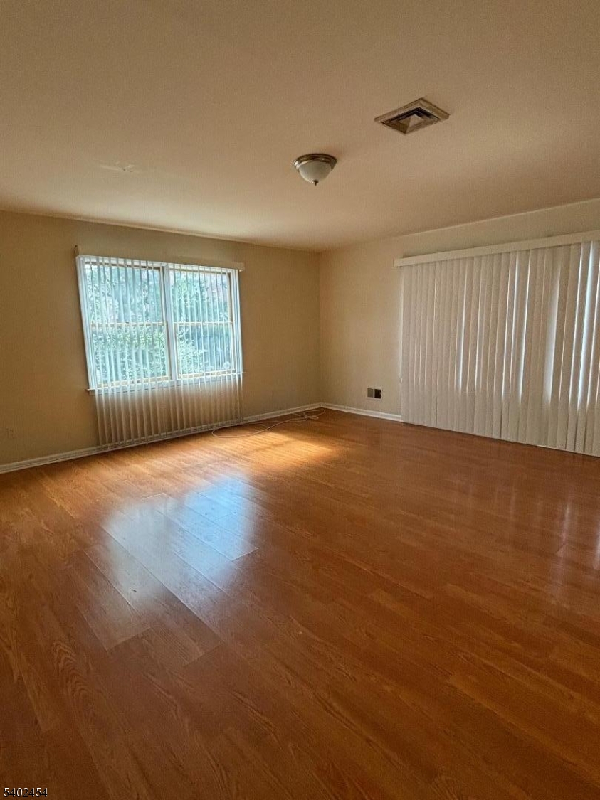 18 Harrison Street Belleville, NJ 07109 - Photo 7 of 18 an empty room with wooden floor and windows