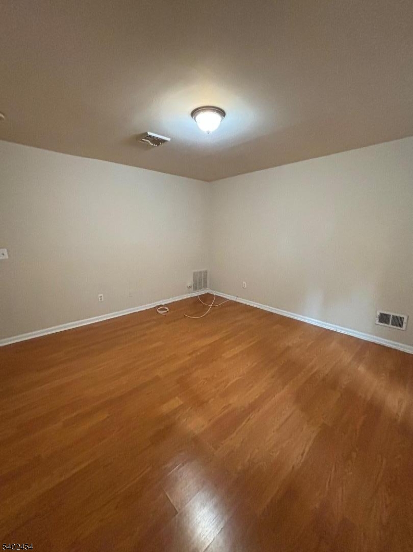 18 Harrison Street Belleville, NJ 07109 - Photo 9 of 18 an empty room with wooden floor and windows