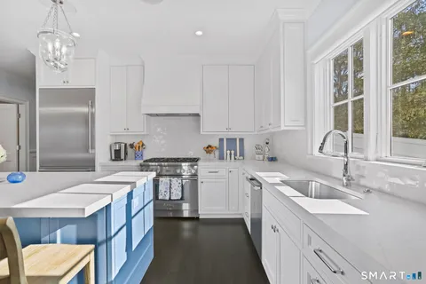 a kitchen with a sink stove top oven and refrigerator