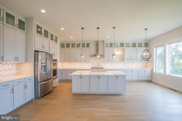 a large kitchen with kitchen island a sink stainless steel appliances and cabinets