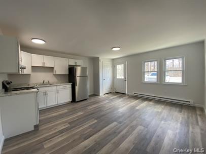 779 Neighborhood Road Lake Katrine, NY 12449 - Photo 7 of 7 Kitchen with white cabinetry, light countertops, dark wood-style floors, freestanding refrigerator, and a baseboard radiator