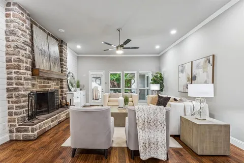 a living room with furniture a fireplace and a large window