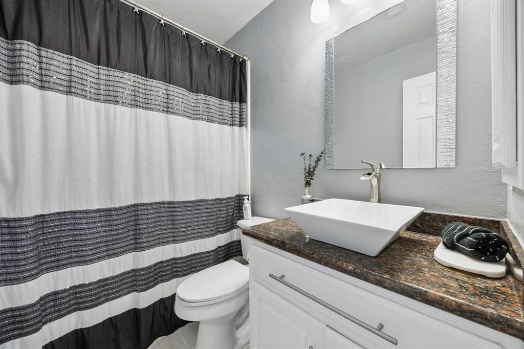 5808 Rathbone Drive Parker, TX 75002 - Photo 18 of 39 Guest bathroom is adjacent to the first floor secondary bedroom. The room has granite countertop with vessel sink, medicine cabinet and tub with shower.