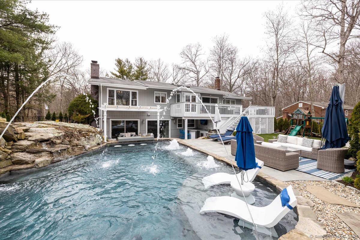 a view of a house with backyard and sitting area