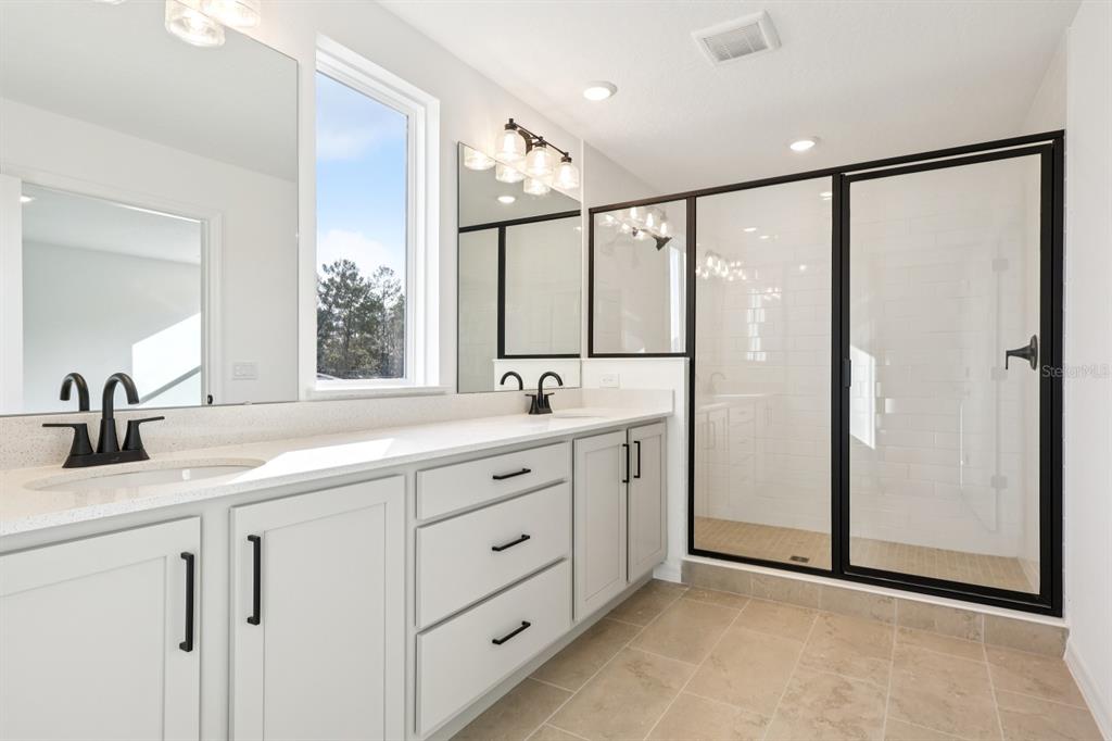 2298 Broadbrook Drive St. Cloud, FL 34771 - Photo 36 of 40 a bathroom with a double vanity sink mirror and shower