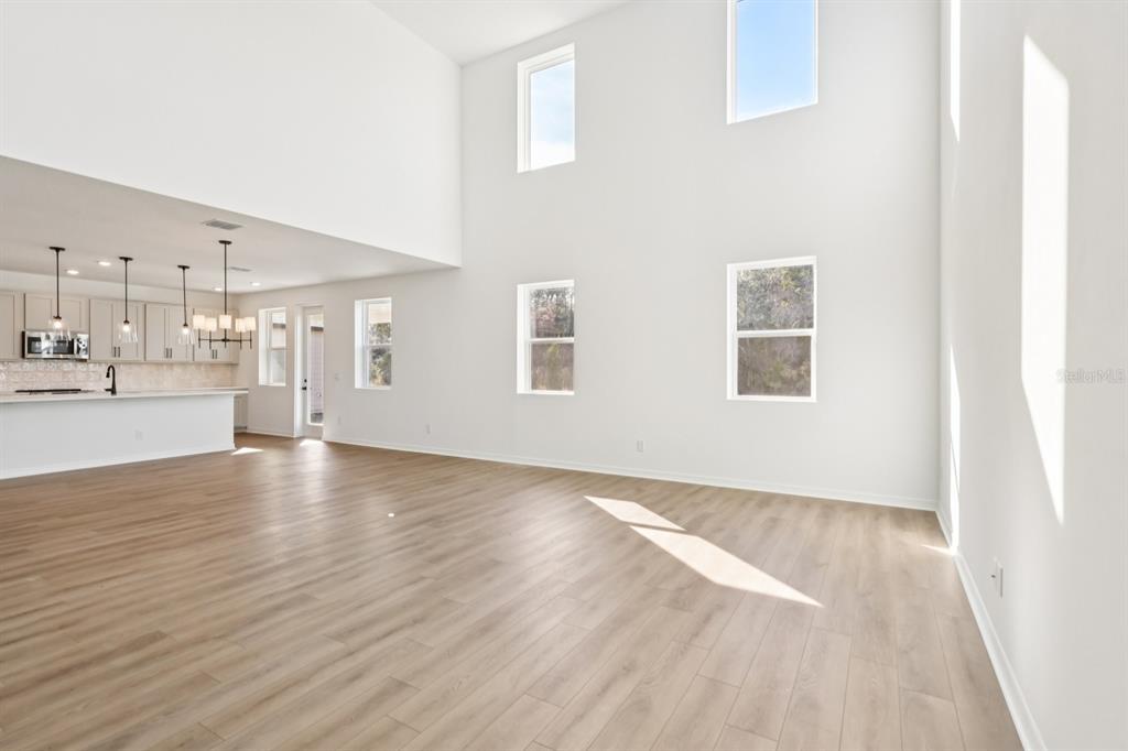 2298 Broadbrook Drive St. Cloud, FL 34771 - Photo 5 of 40 an empty room with wooden floor and windows
