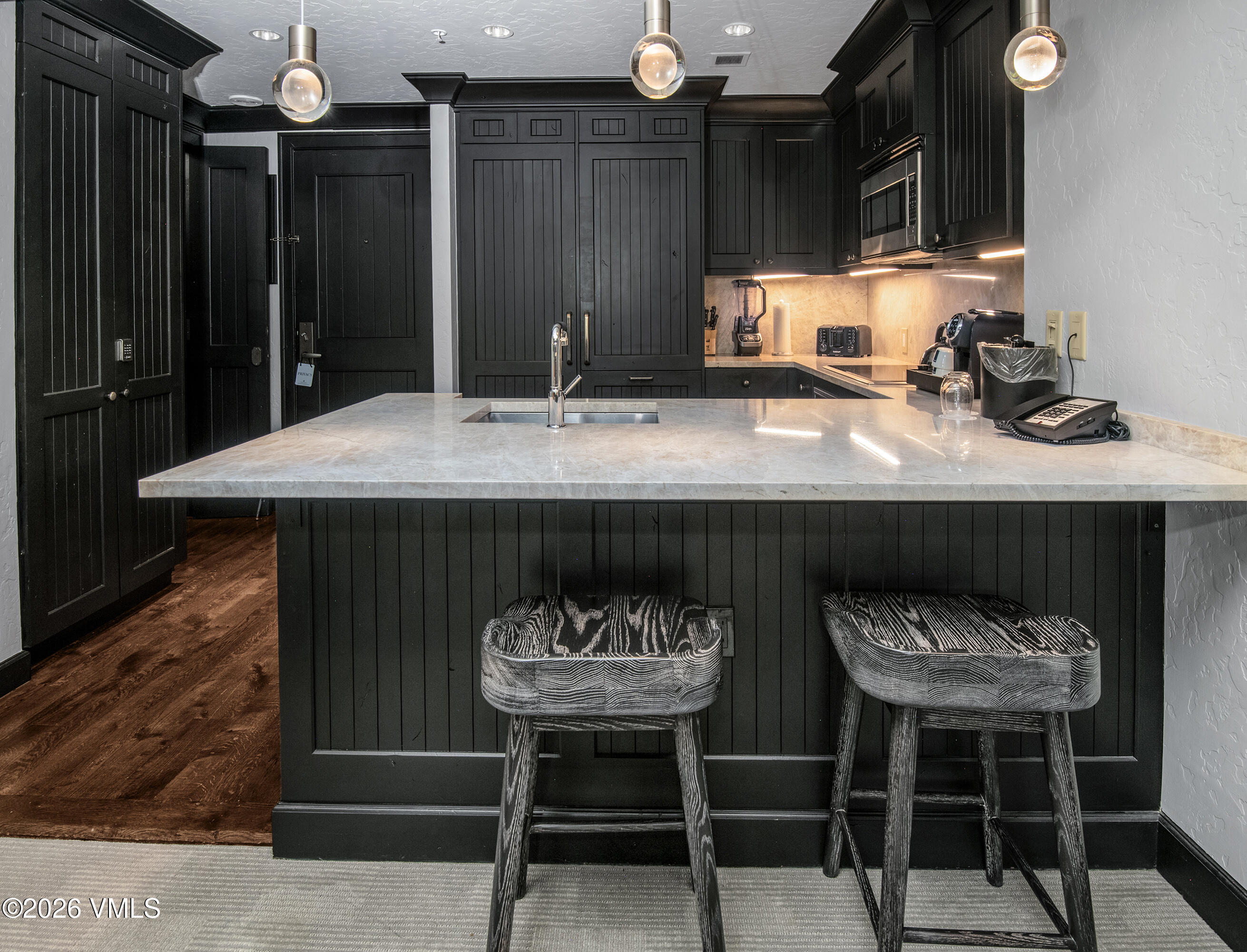 130 Daybreak Ridge Road, Unit HS716 Avon, CO 81620 - Photo 9 of 25 a kitchen with a sink and chairs