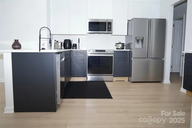 a kitchen with stainless steel appliances granite countertop a refrigerator and a sink