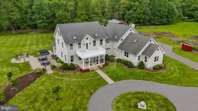 a view of a swimming pool with a yard and large trees