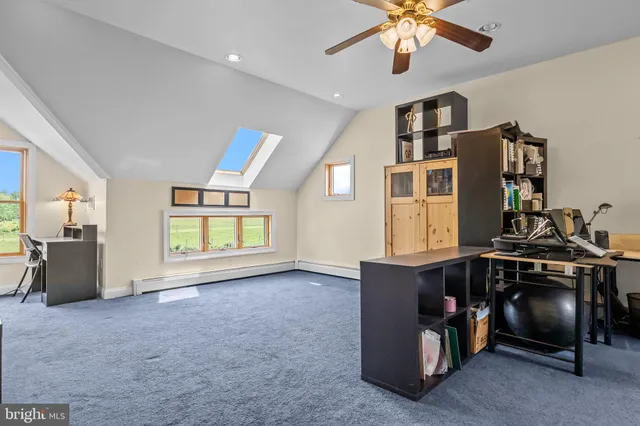 an aerial view of a residential houses with outdoor space and trees all around