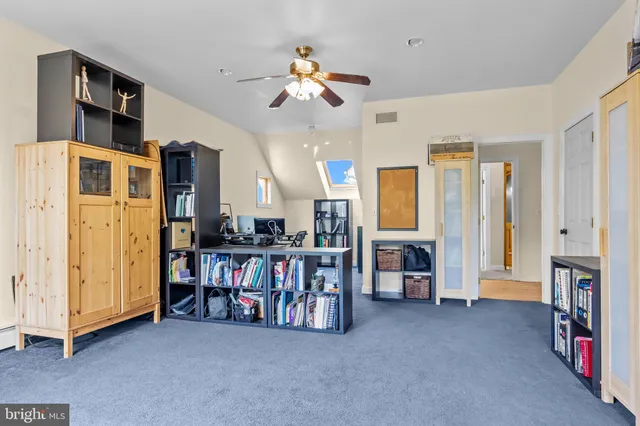 an aerial view of a residential houses with outdoor space and trees all around