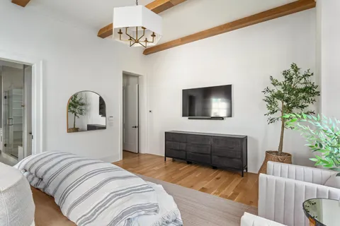 a bedroom with a bed and a flat screen tv