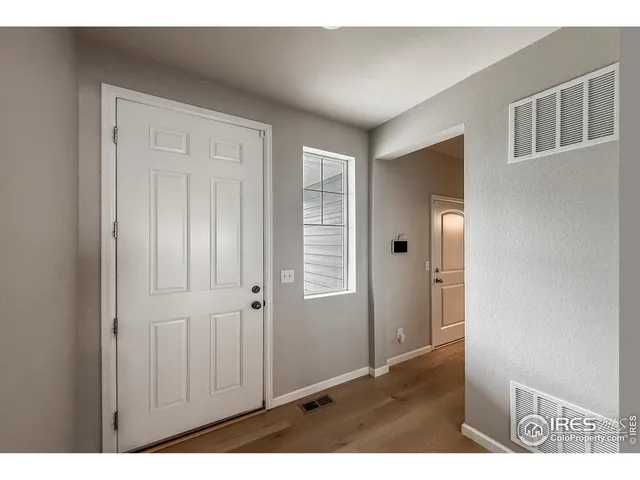 a view of an empty room with closet and a window