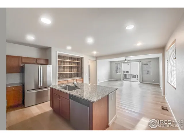 a kitchen with stainless steel appliances granite countertop a sink refrigerator and cabinets