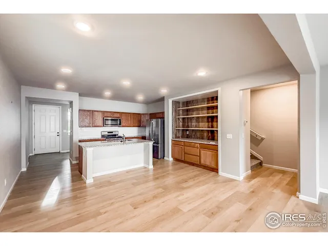 a large white kitchen with kitchen island a sink a stove a refrigerator and a counter top space