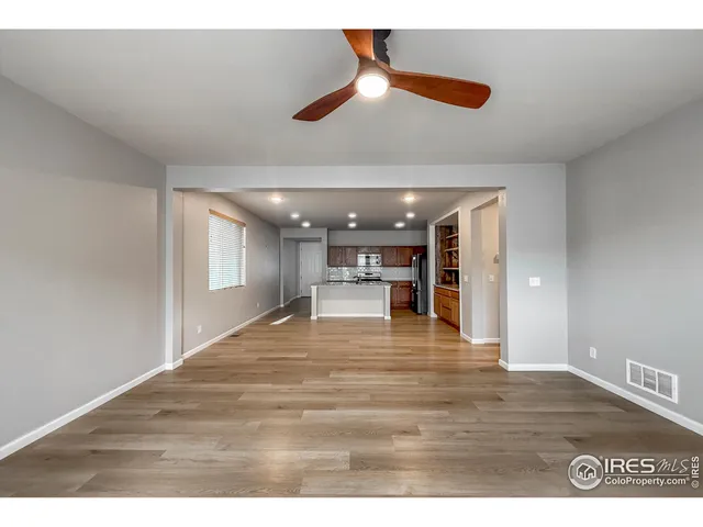 a view of an empty room and kitchen