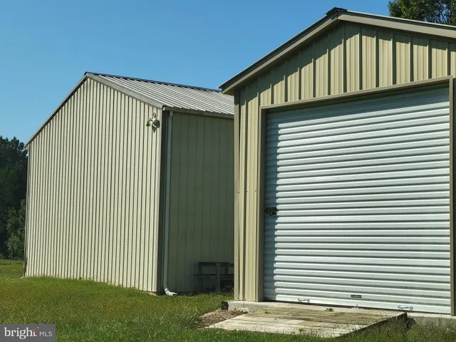 a blue house with a small yard and trees in the back