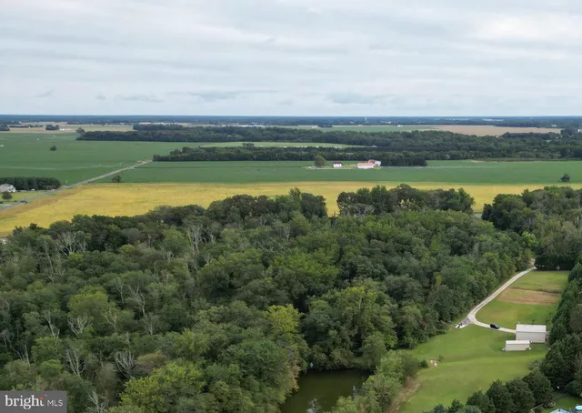 an aerial view of a houses with a yard and lake view
