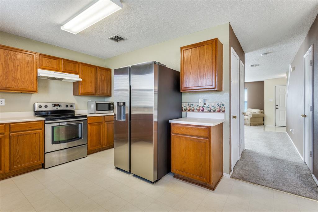 2532 Timberbrook Trail McKinney, TX 75071 - Photo 14 of 32 a kitchen with stainless steel appliances a refrigerator stove and sink