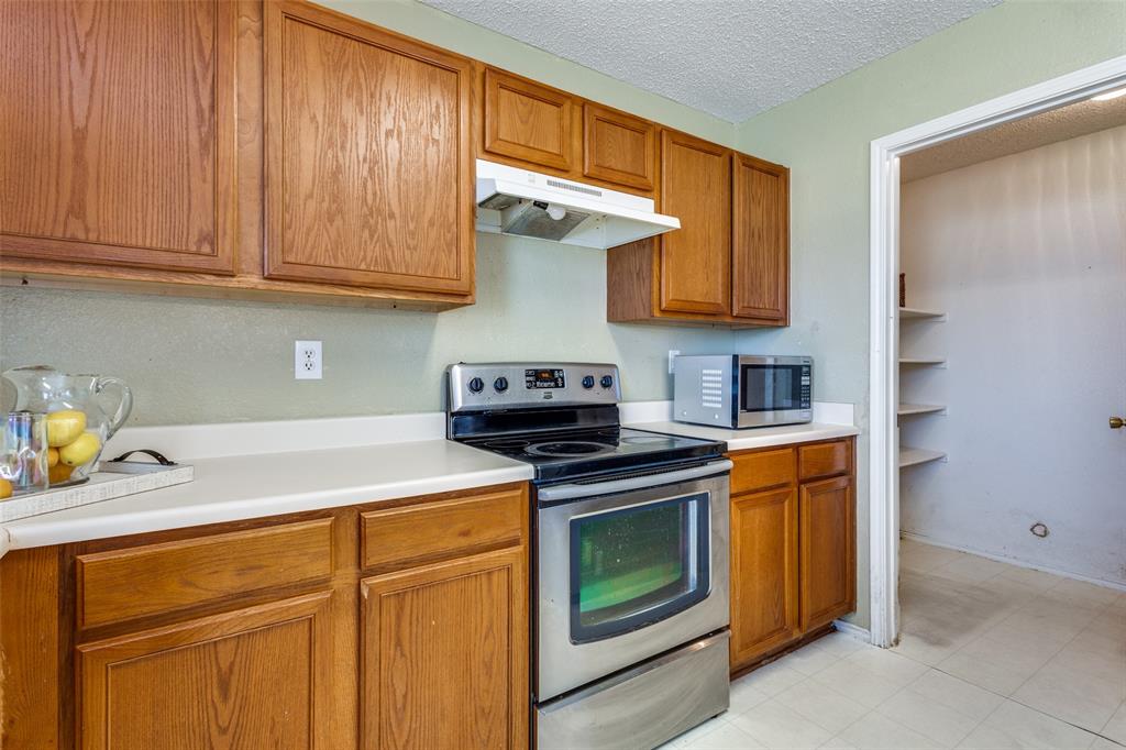 2532 Timberbrook Trail McKinney, TX 75071 - Photo 15 of 32 a kitchen with stainless steel appliances granite countertop a stove a sink and a microwave